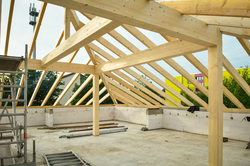 Heavy timber roof trusses erected against open sky
