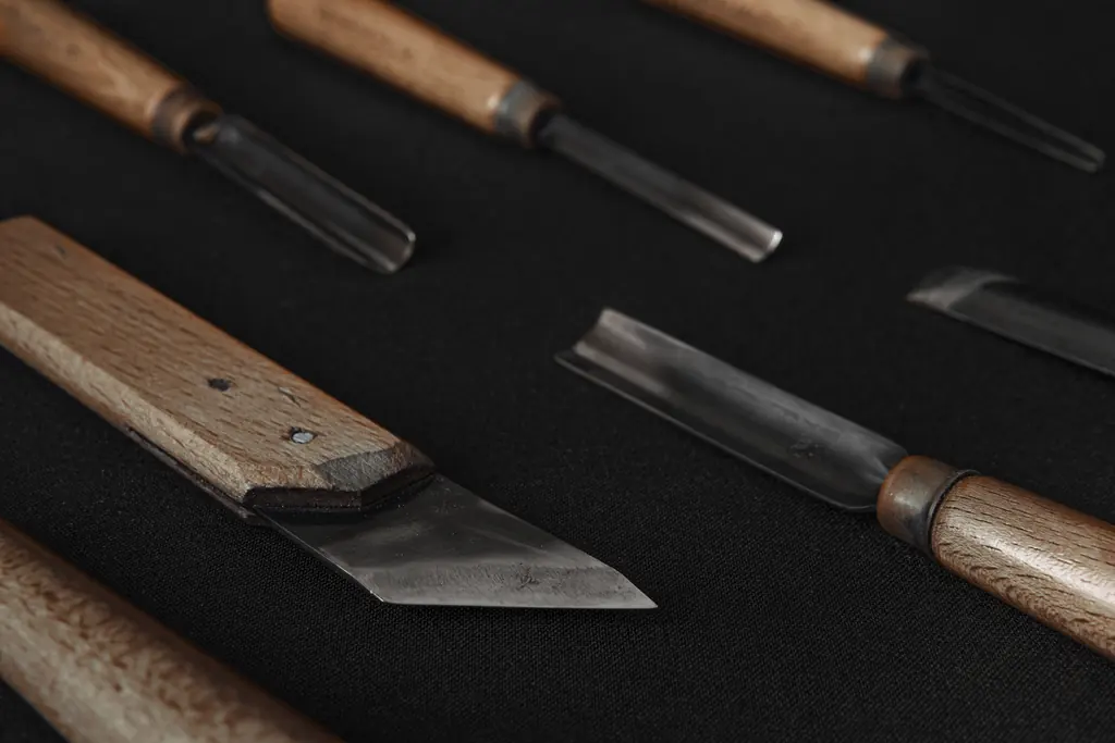 Row of bench chisels laid out on dark felt