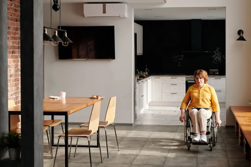 Wheelchair user moving freely through an open plan kitchen and dining space
