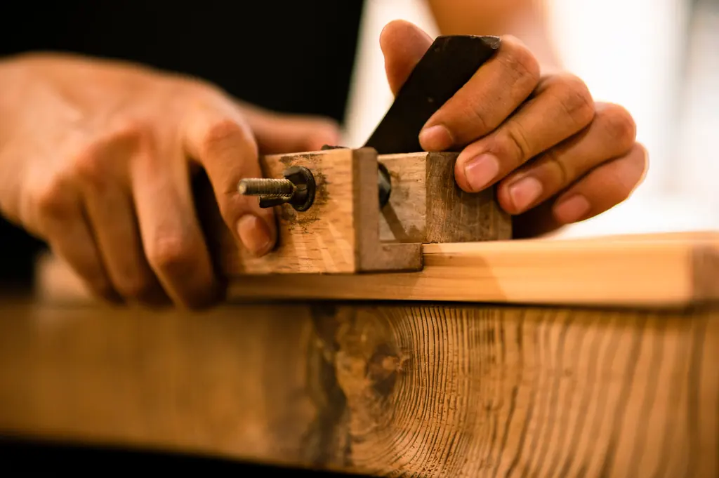 Carpenter running a block plane along a length of live edge stock