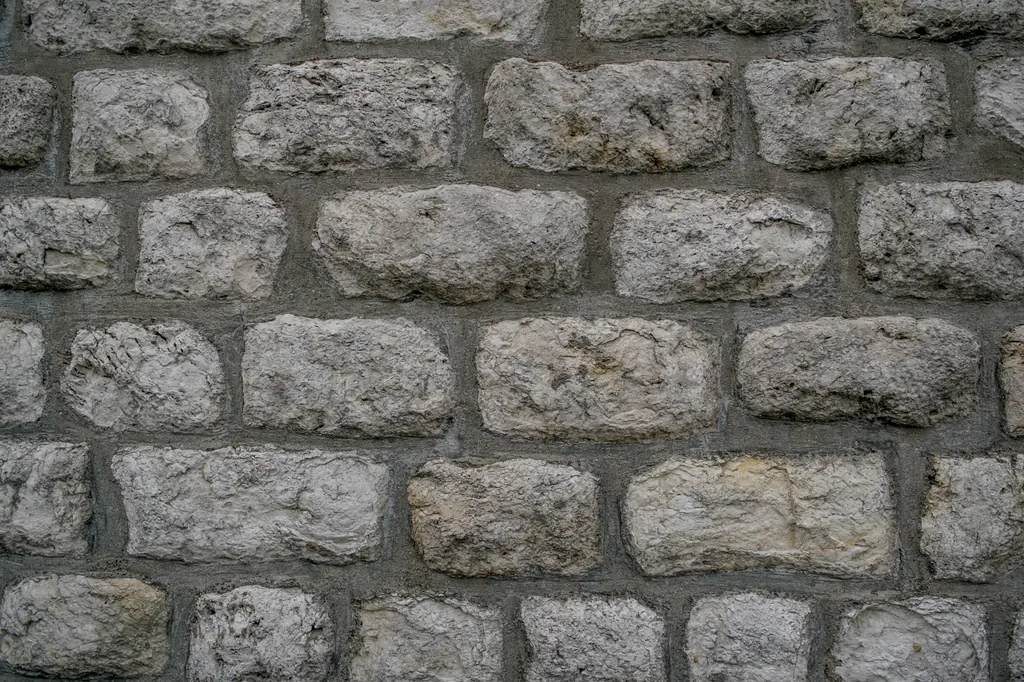 Dry-laid stone retaining wall with tight joints and level coursing