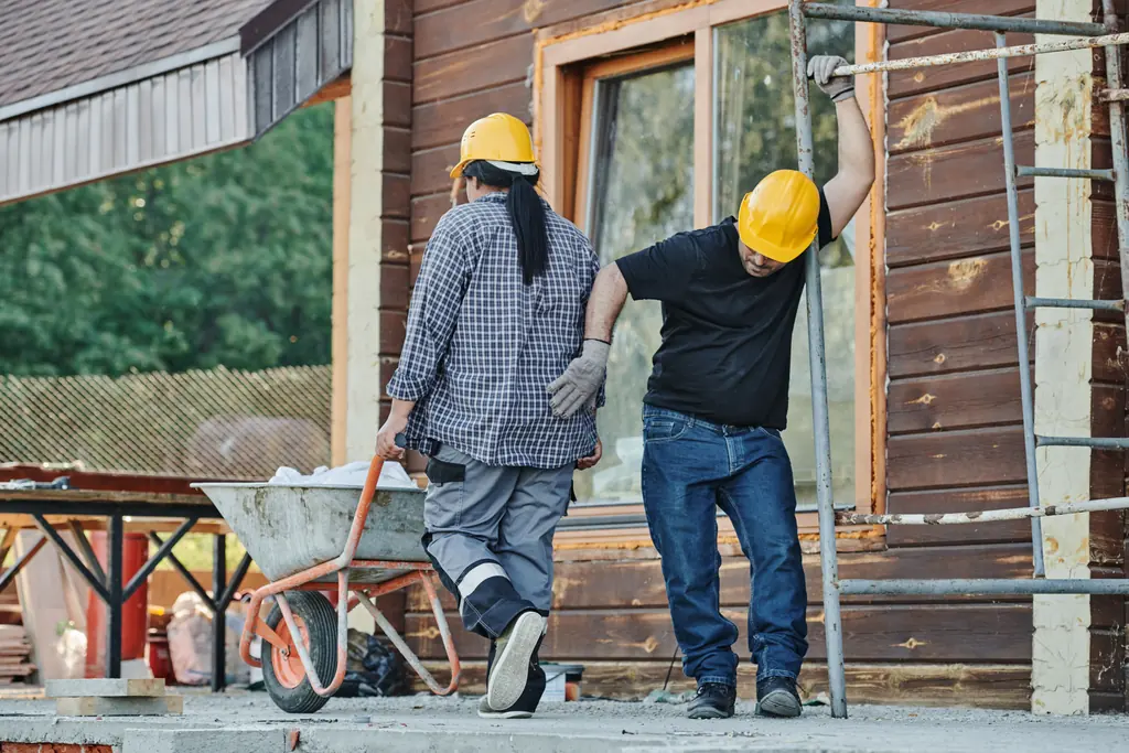 Two builders working together on a timber deck frame