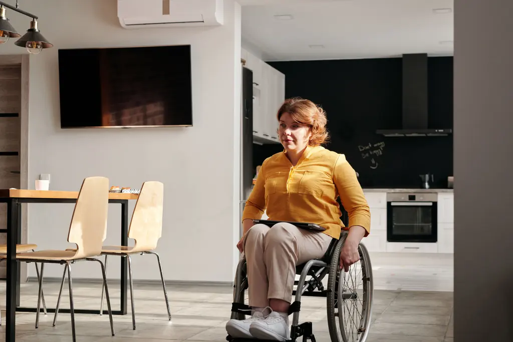 Wheelchair user at home in a bright open plan living space